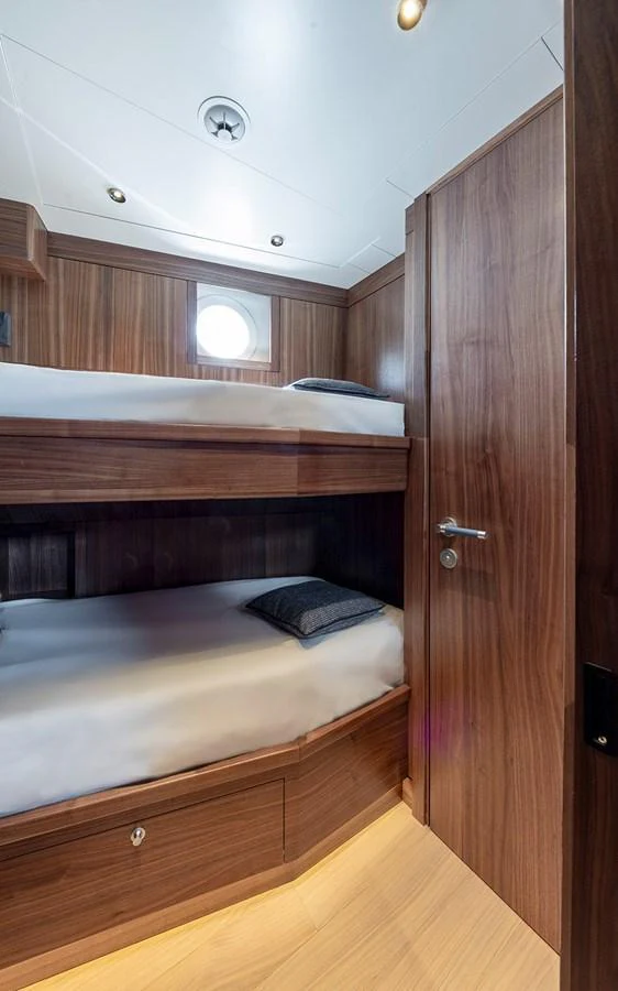 A cozy cabin with wooden finishes and bunk beds, perfect for a restful night at sea. aboard EMPIRE Yacht for Sale