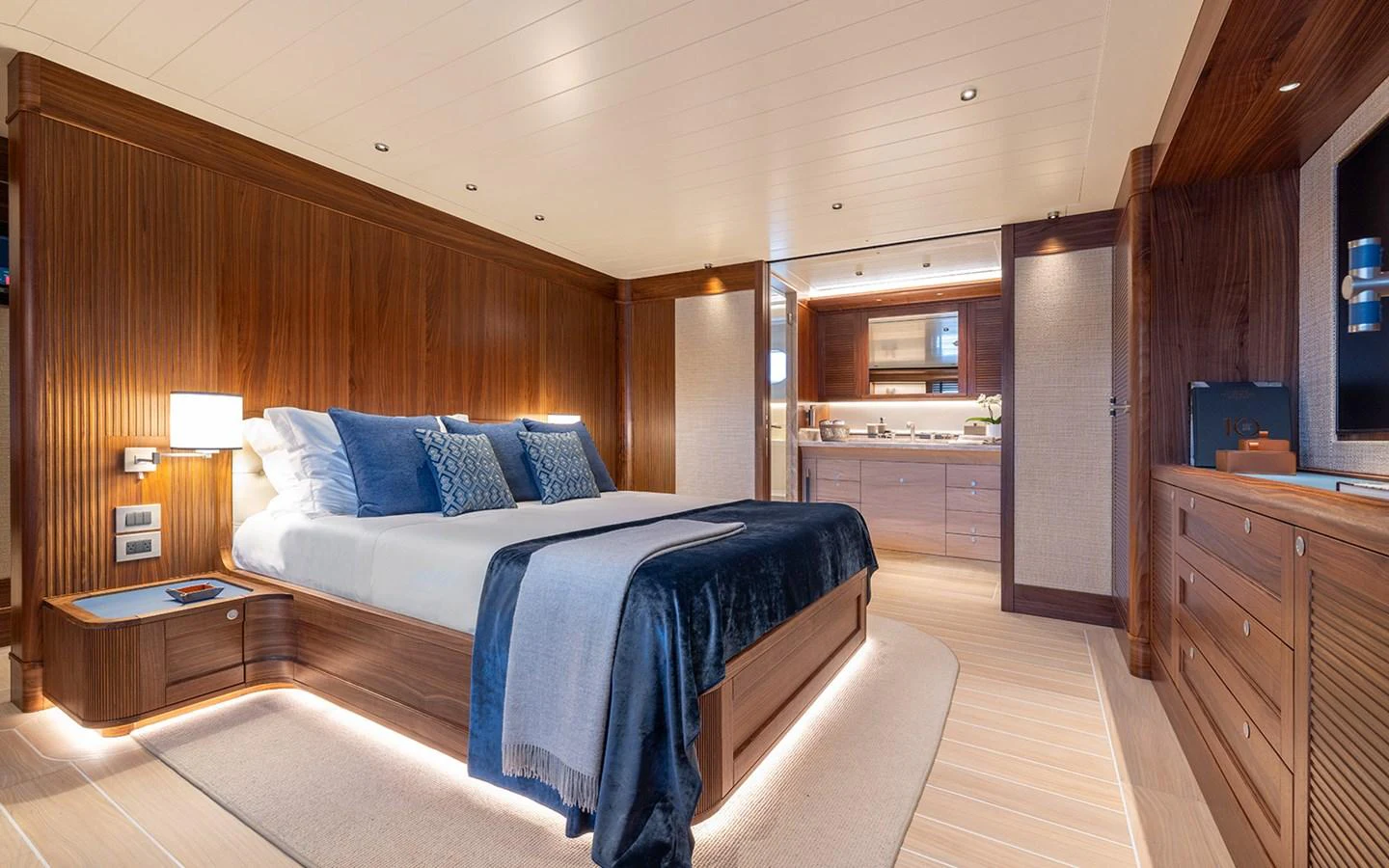 The master stateroom features luxurious wood paneling, a spacious bed, and elegant lighting. aboard EMPIRE Yacht for Sale