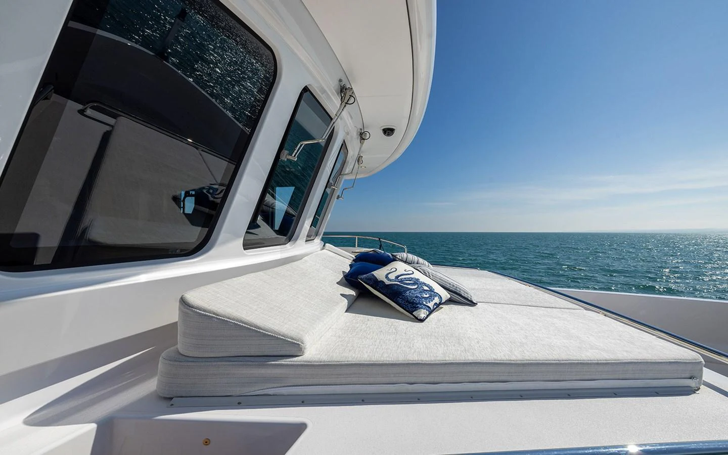 The foredeck features a luxurious sunpad with plush cushions, perfect for relaxing while enjoying the sea view. aboard EMPIRE Yacht for Sale