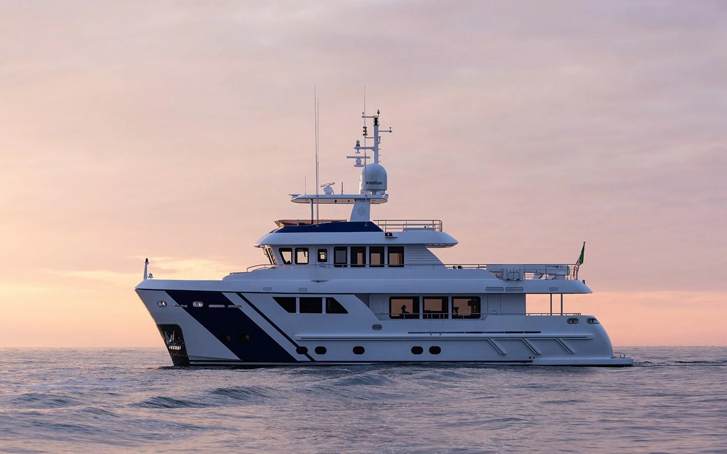 A luxurious yacht cruises serenely on calm waters at sunset. aboard EMPIRE Yacht for Sale