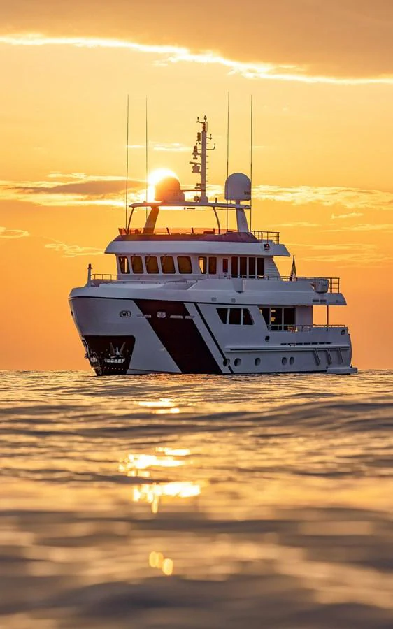A stunning yacht is captured at sunset, creating a serene and picturesque scene on the water. aboard EMPIRE Yacht for Sale