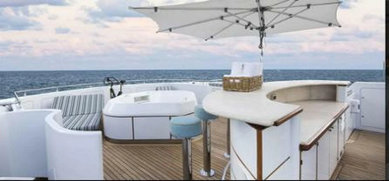 a white table and chairs on a deck overlooking a body of water aboard UNFORGETTABLE Yacht for Sale