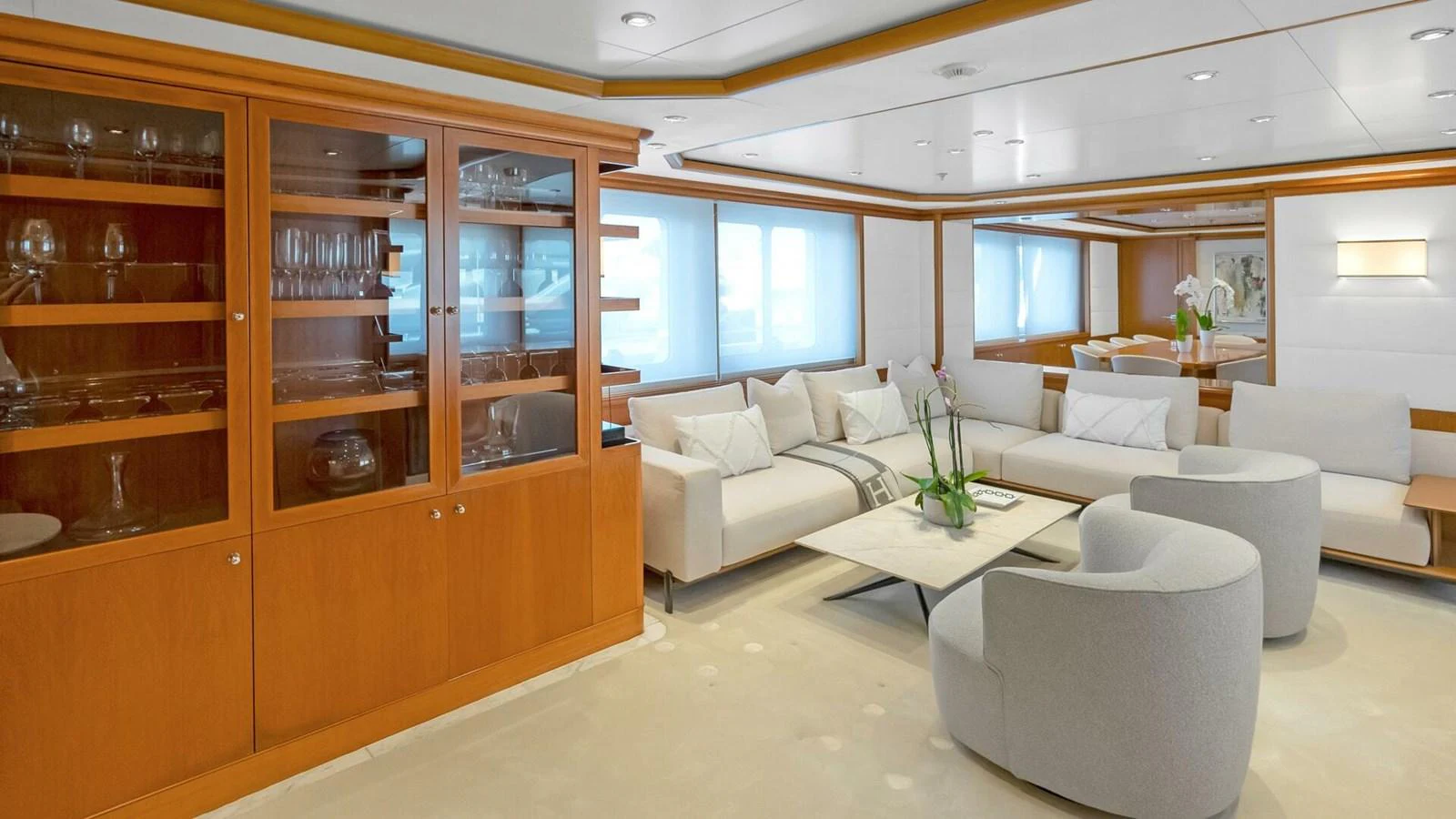a living room with a white couch and a large shelving unit aboard UNFORGETTABLE Yacht for Sale