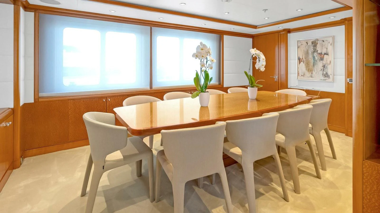 a dining table with white chairs aboard UNFORGETTABLE Yacht for Sale