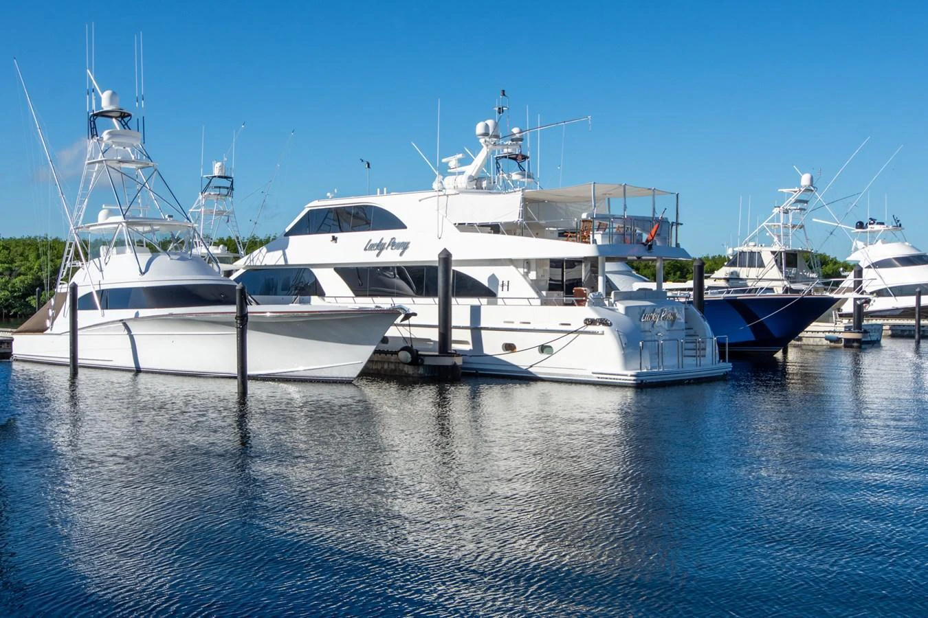 A luxurious yacht is docked at a marina, showcasing its sleek design and spacious decks. aboard LUCKY PENNY Yacht for Sale