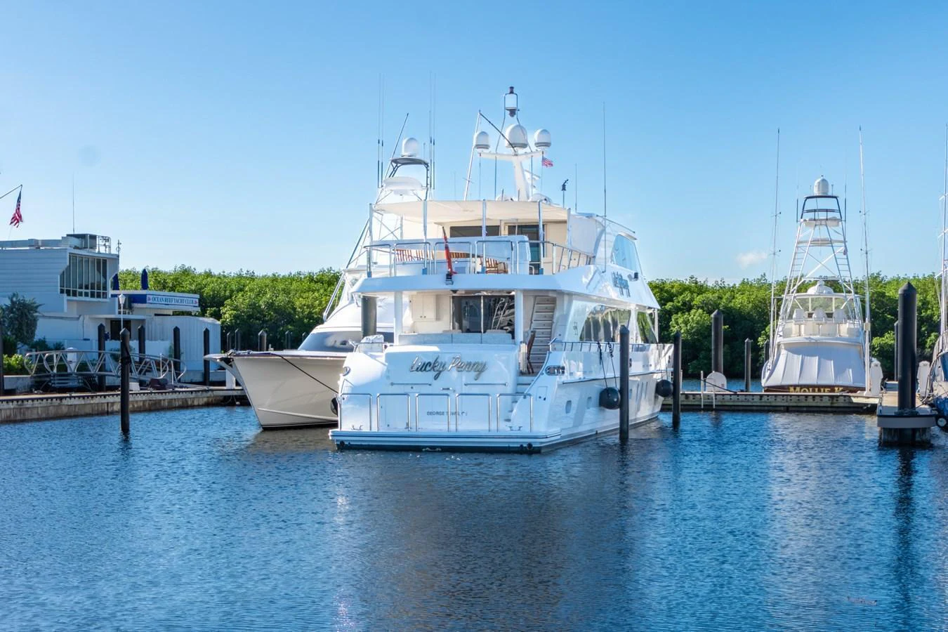 A luxurious yacht is docked at a serene marina, showcasing its elegant design and spacious decks. aboard LUCKY PENNY Yacht for Sale