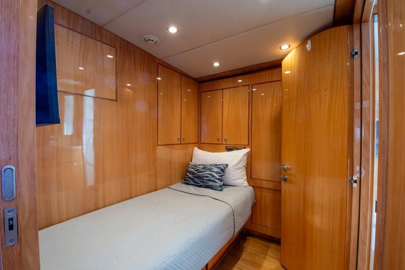 A cozy guest cabin featuring a single bed and wooden cabinetry. aboard LUCKY PENNY Yacht for Sale