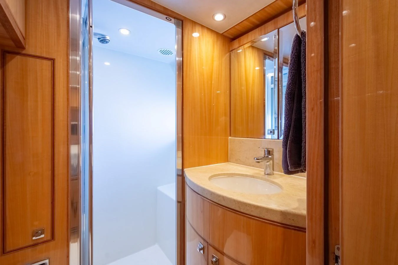 The yacht's bathroom features elegant wood paneling and modern fixtures. aboard LUCKY PENNY Yacht for Sale