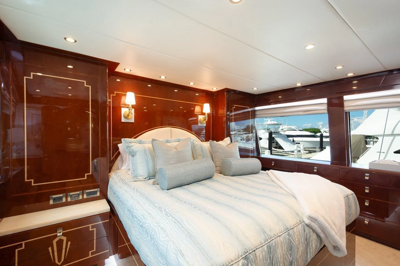 The master stateroom features a luxurious bed with elegant wood paneling and large windows offering a marina view. aboard LUCKY PENNY Yacht for Sale