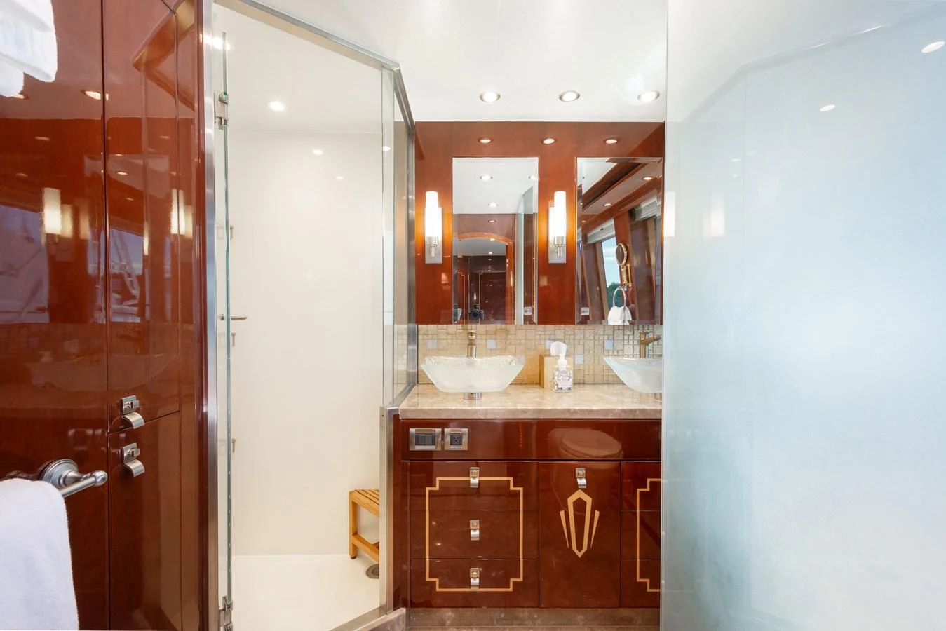 The yacht's bathroom features elegant wood finishes, dual sinks, and a spacious shower area. aboard LUCKY PENNY Yacht for Sale
