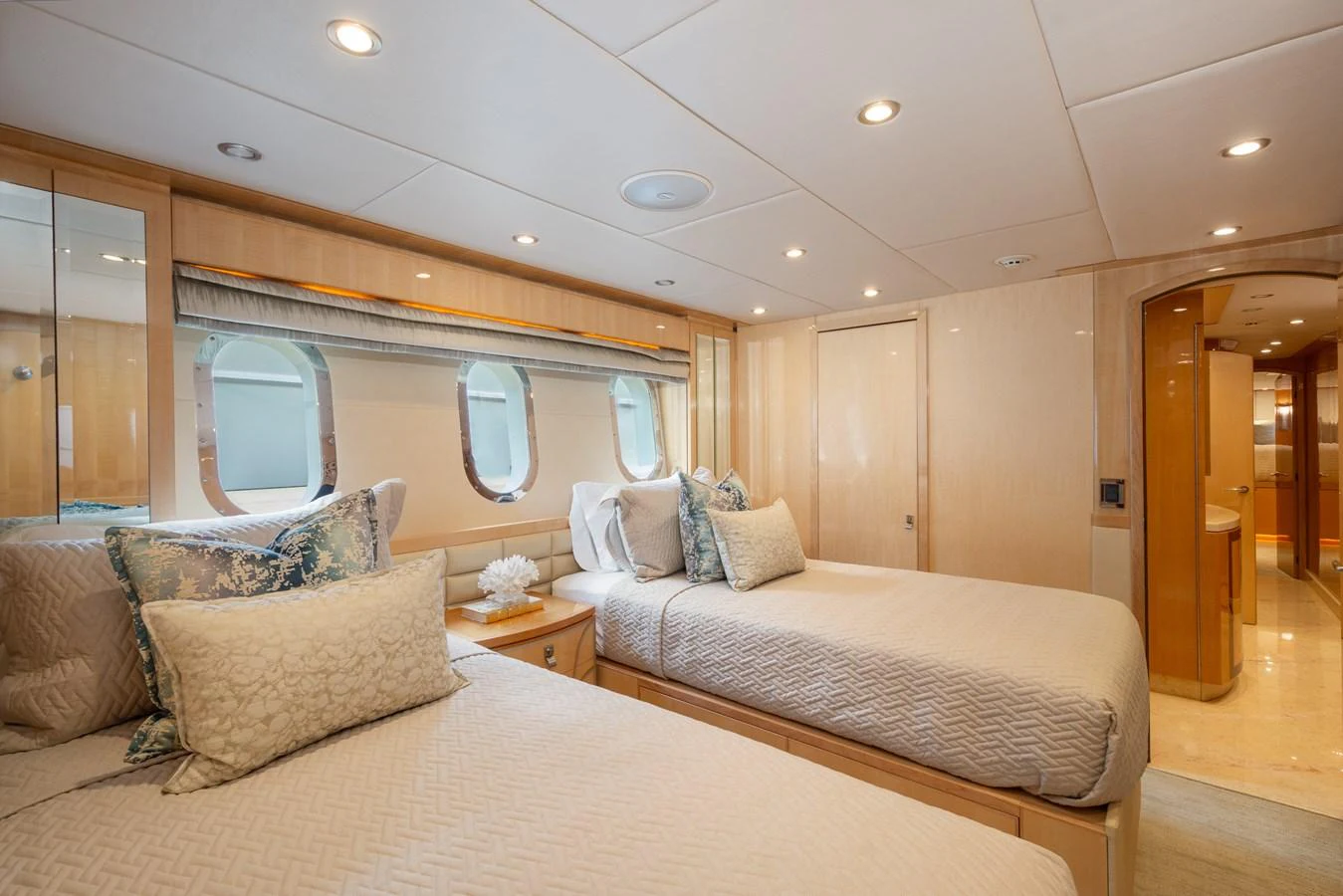 The guest stateroom features two comfortable twin beds with elegant bedding and ample natural light from the porthole windows. aboard LUCKY PENNY Yacht for Sale