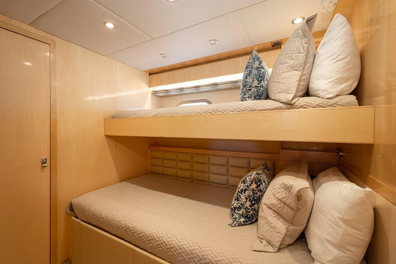 The cozy guest cabin features a bunk bed setup with plush pillows and soft lighting. aboard LUCKY PENNY Yacht for Sale