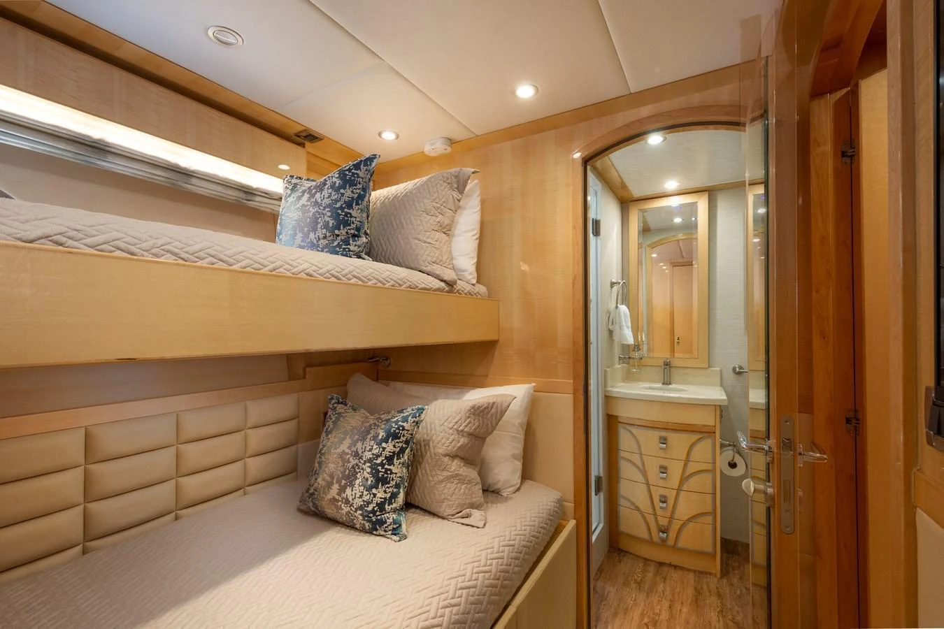 The cozy guest stateroom features bunk beds and an ensuite bathroom, offering a comfortable retreat for guests. aboard LUCKY PENNY Yacht for Sale