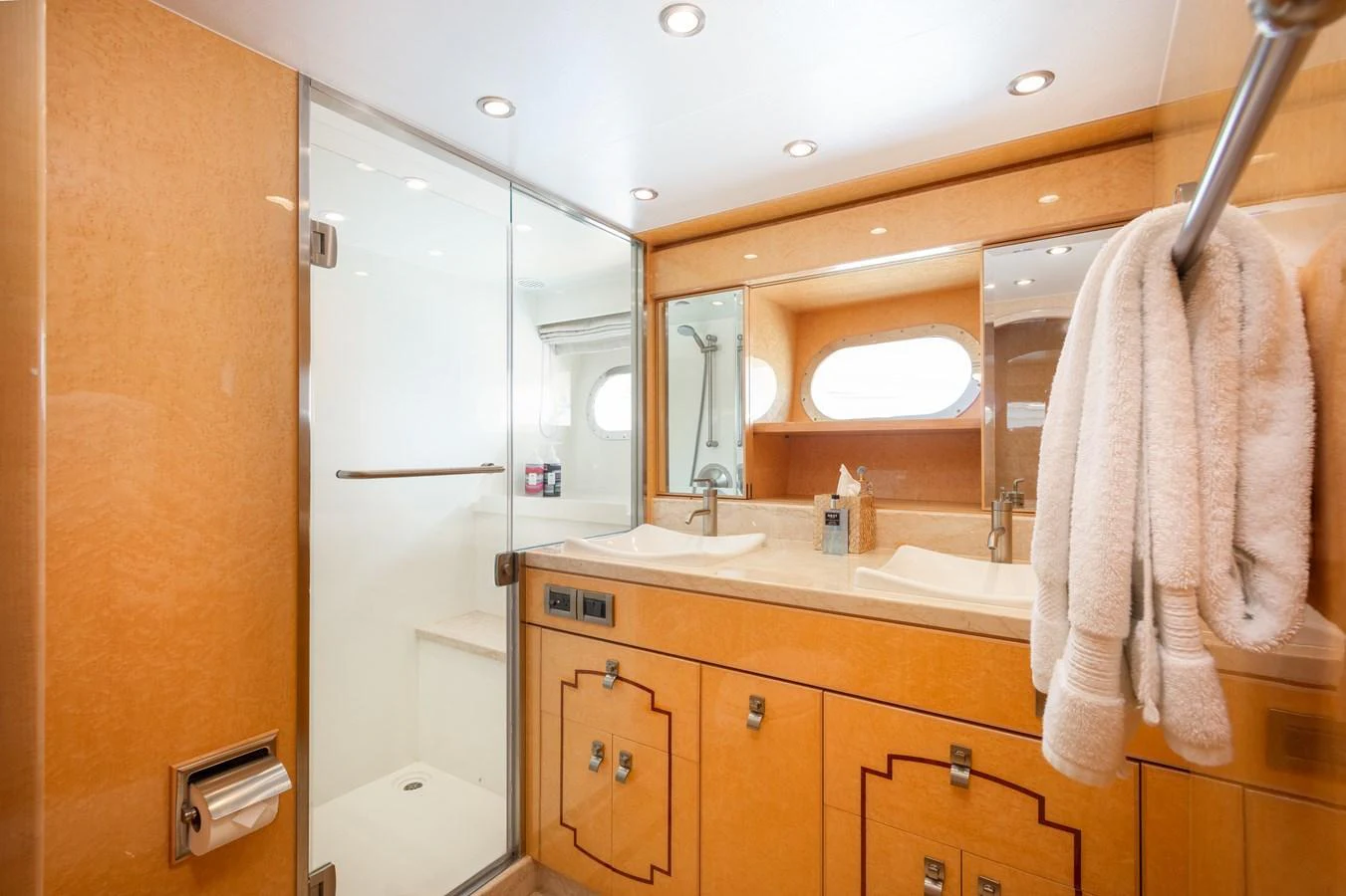 The yacht's bathroom features a spacious layout with a glass-enclosed shower and double sinks. aboard LUCKY PENNY Yacht for Sale