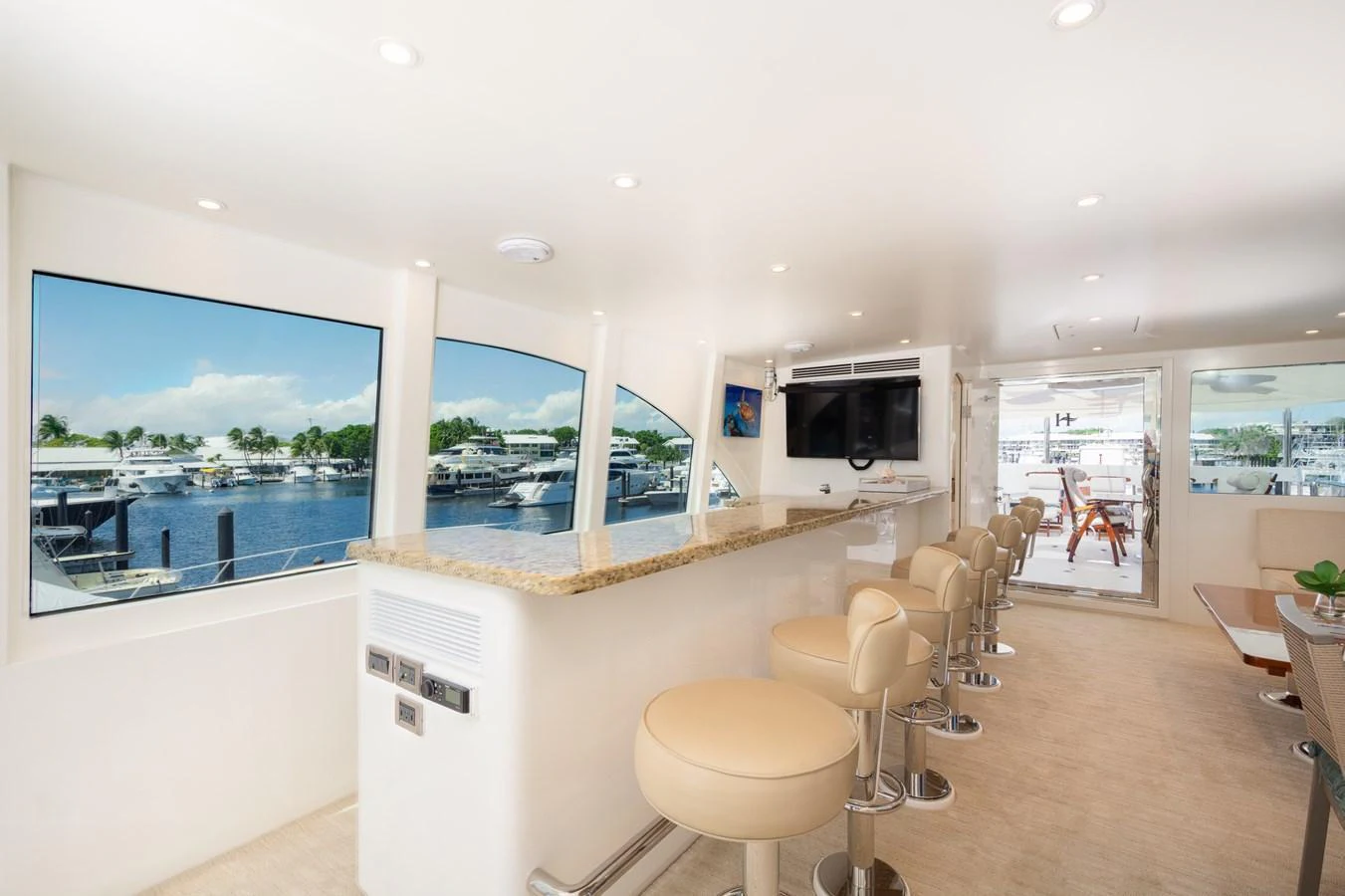 The yacht's interior features a stylish bar area with ample seating and large windows offering scenic views. aboard LUCKY PENNY Yacht for Sale