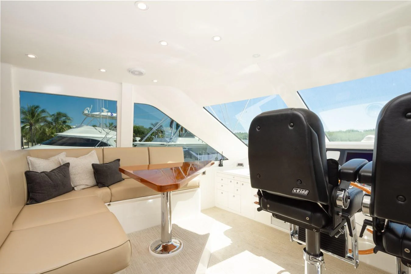 The helm area features comfortable seating and a sleek, modern design with large windows offering expansive views. aboard LUCKY PENNY Yacht for Sale