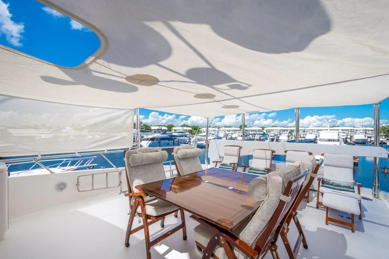 The sundeck offers a spacious and shaded area with comfortable seating and a dining table, perfect for enjoying meals with a view. aboard LUCKY PENNY Yacht for Sale