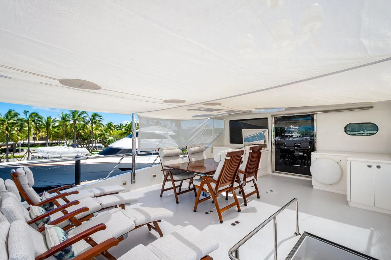 The aft deck features a spacious outdoor dining area with comfortable seating and a shaded canopy. aboard LUCKY PENNY Yacht for Sale