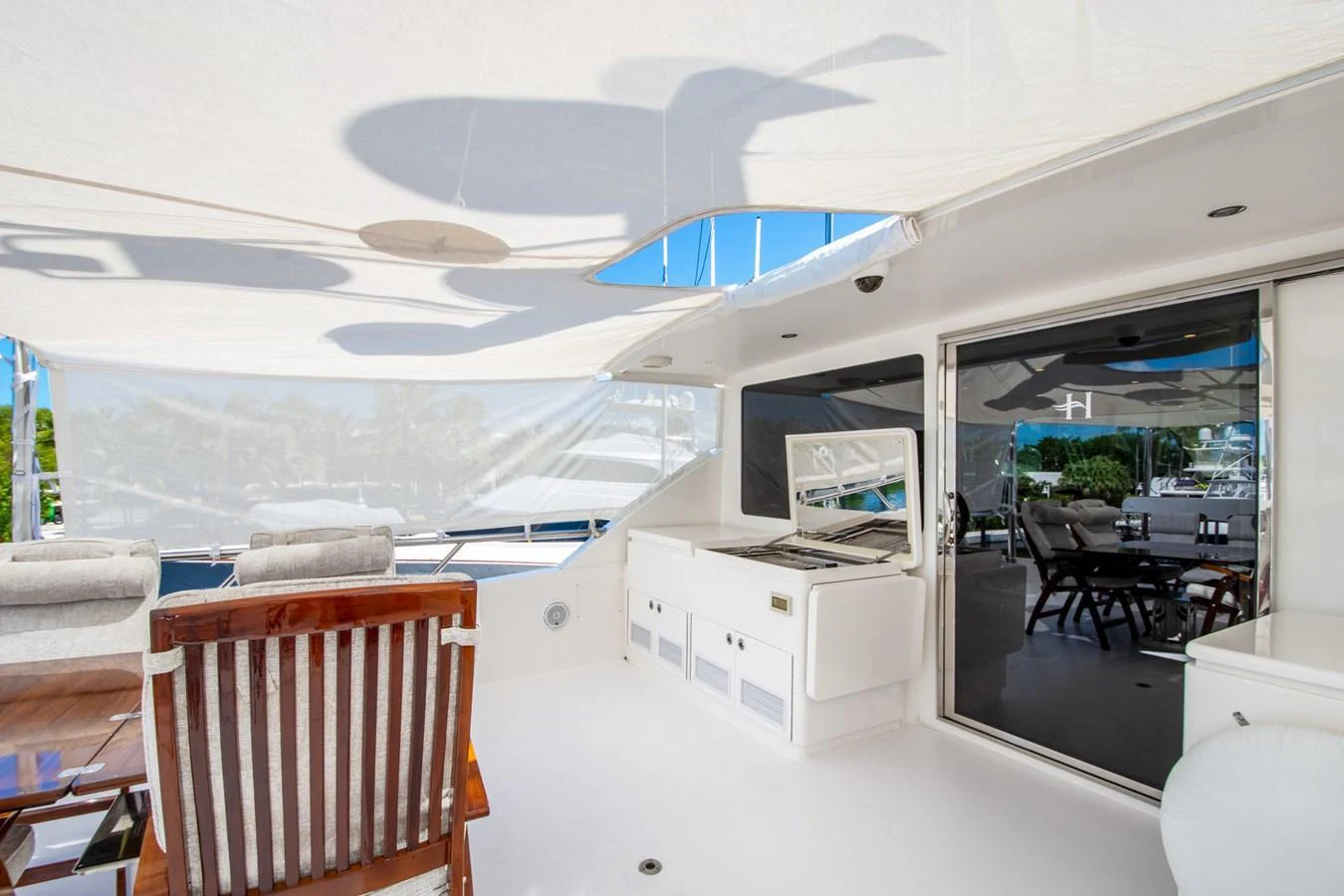 The aft deck features a shaded lounging area with comfortable seating and a sleek, modern design. aboard LUCKY PENNY Yacht for Sale