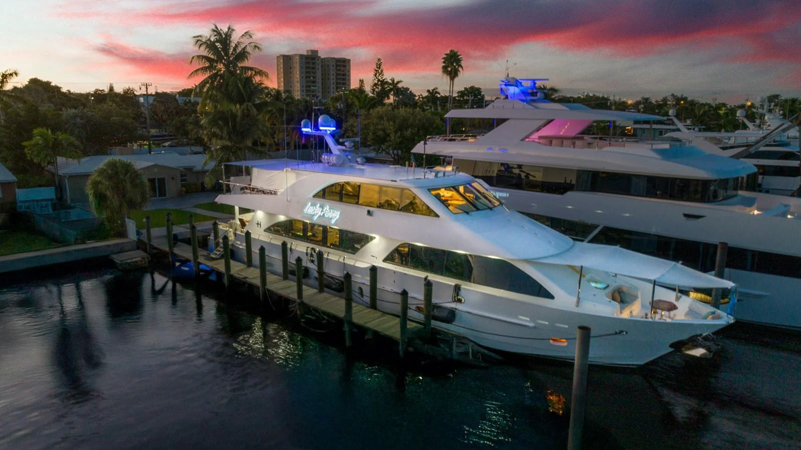 A luxurious yacht docked at a marina during a stunning sunset. aboard LUCKY PENNY Yacht for Sale