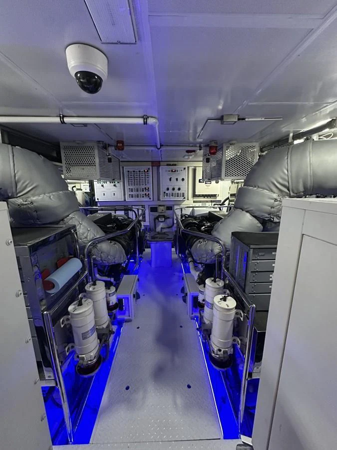 The image showcases the yacht's well-maintained engine room with advanced machinery and blue ambient lighting. aboard LUCKY PENNY Yacht for Sale