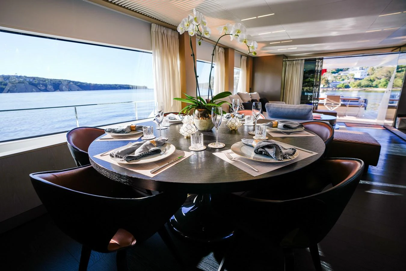 a dining table with plates and glasses aboard TORO Yacht for Sale