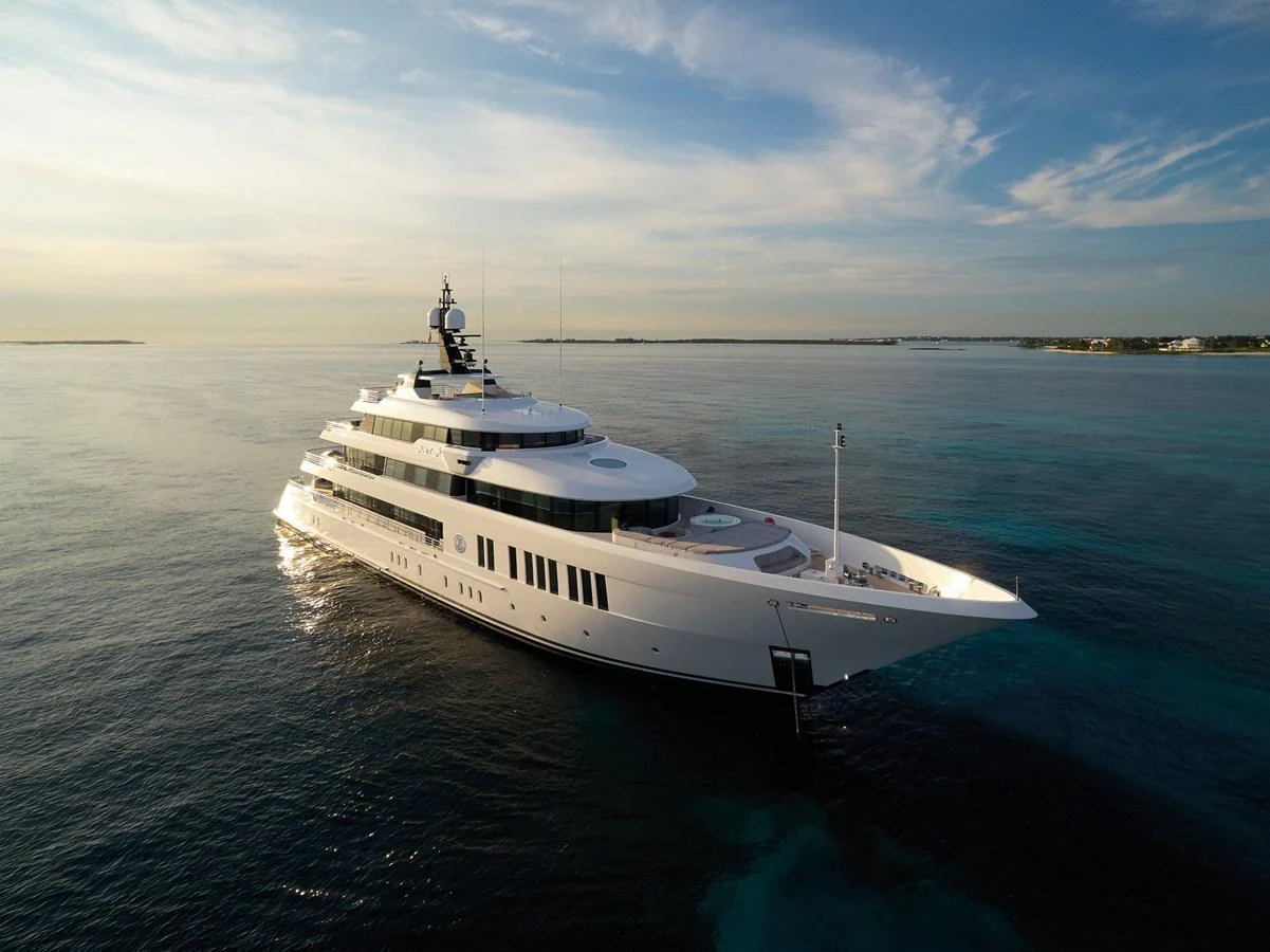 A luxurious yacht cruises gracefully on calm waters under a serene sky. aboard JUST J'S Yacht for Sale