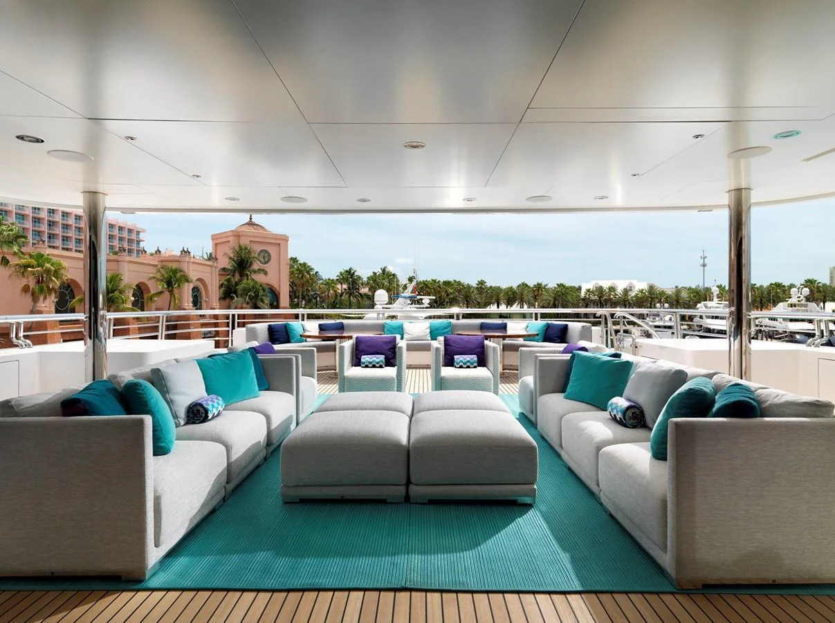 The aft deck features a luxurious seating area with plush sofas and vibrant accents, perfect for relaxation and socializing. aboard JUST J'S Yacht for Sale