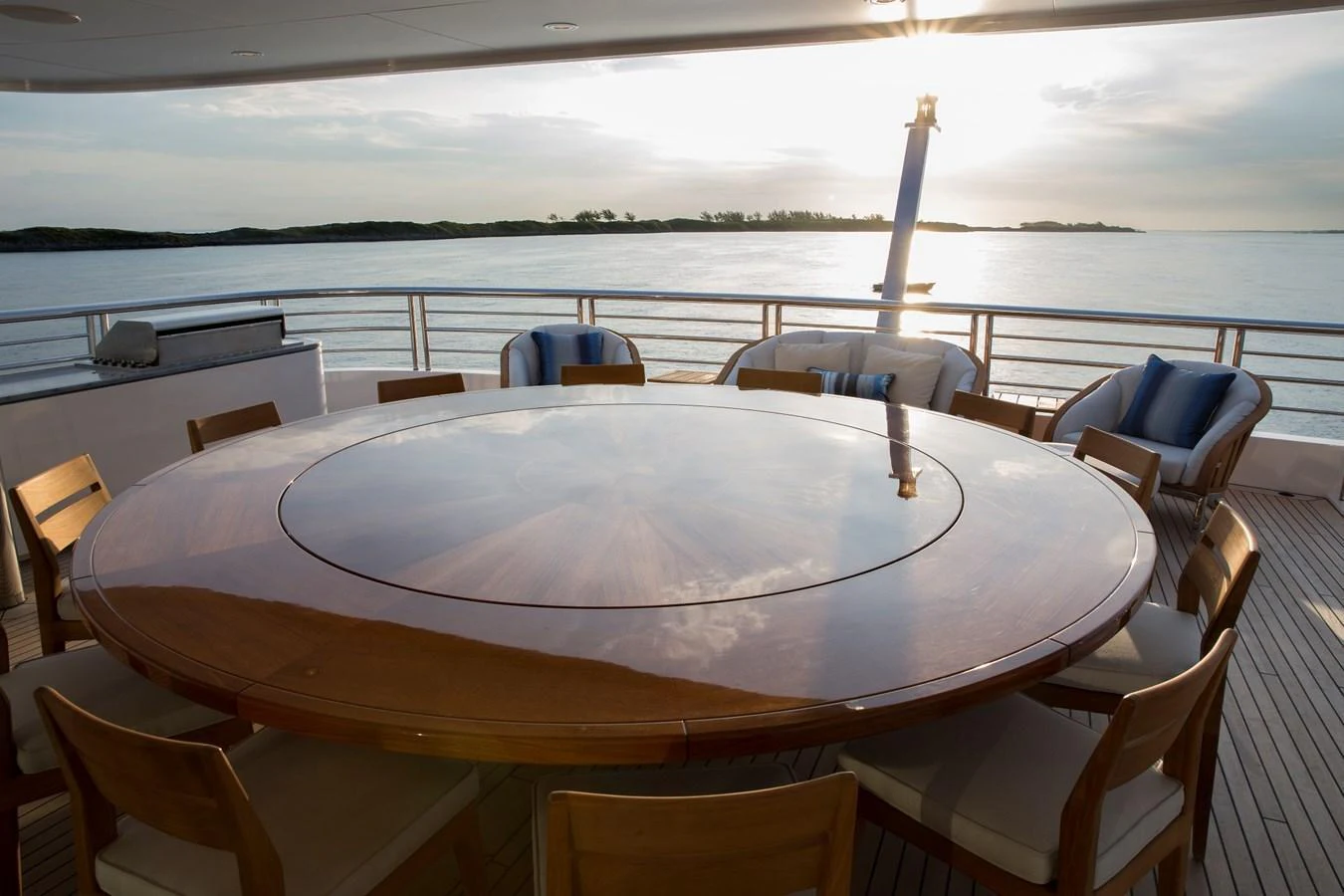 The aft deck features a large circular dining table with comfortable seating, perfect for enjoying meals with a view of the water. aboard JUST J'S Yacht for Sale