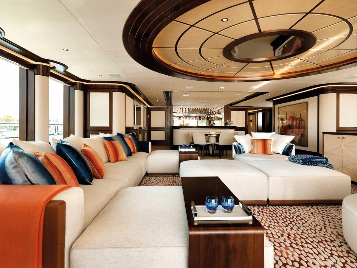 The salon features luxurious seating with vibrant cushions and a sophisticated bar area. aboard JUST J'S Yacht for Sale