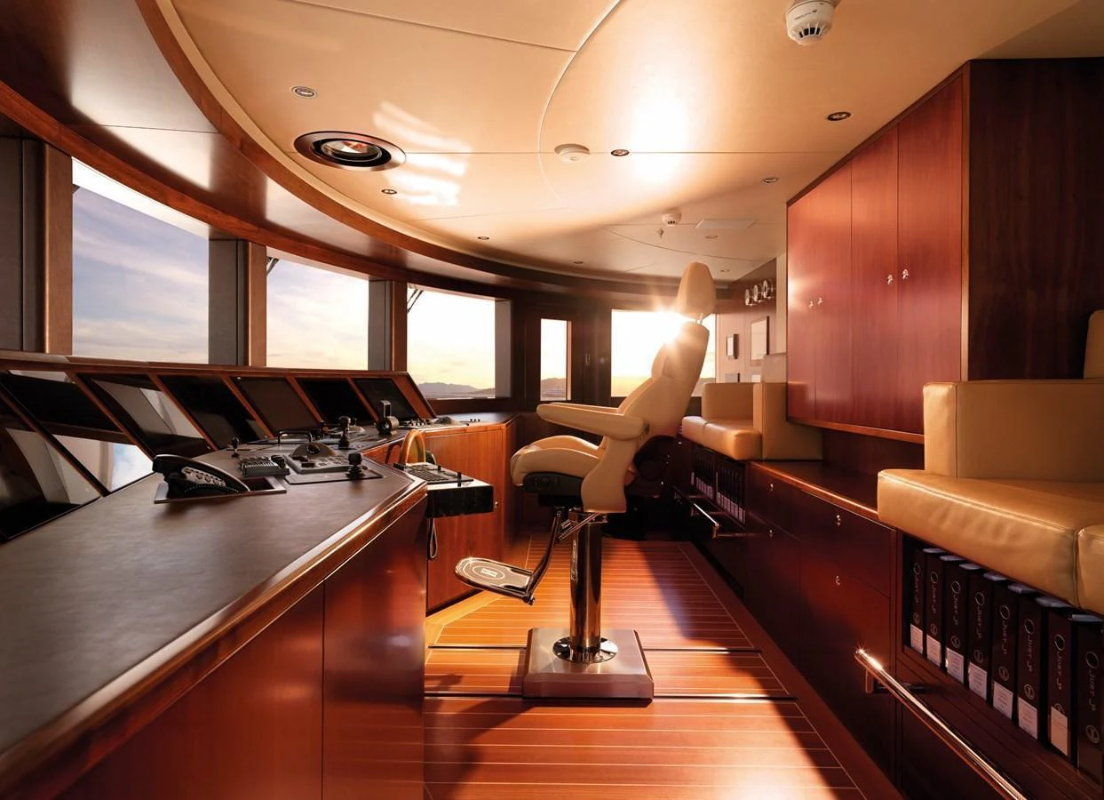 The helm features a sophisticated control area with panoramic windows and luxurious wood finishes. aboard JUST J'S Yacht for Sale