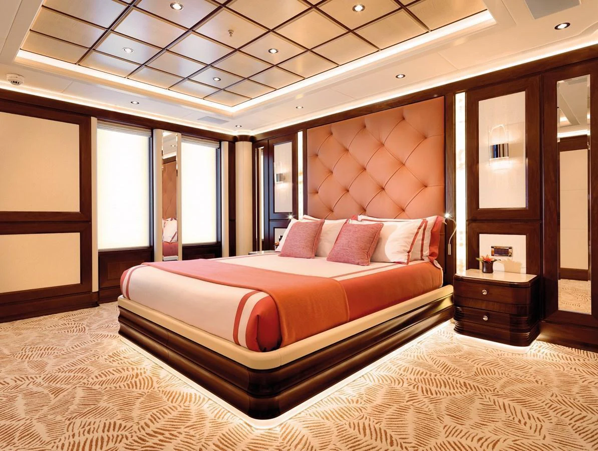 The master stateroom features a luxurious bed with elegant lighting and rich wood finishes. aboard JUST J'S Yacht for Sale