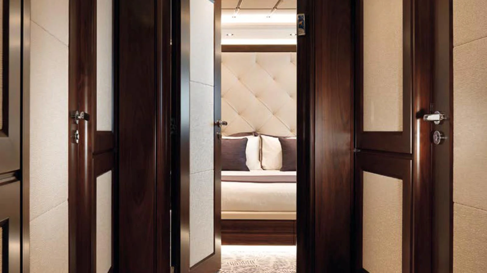 The image showcases a luxurious stateroom with elegant wood finishes and plush bedding. aboard JUST J'S Yacht for Sale