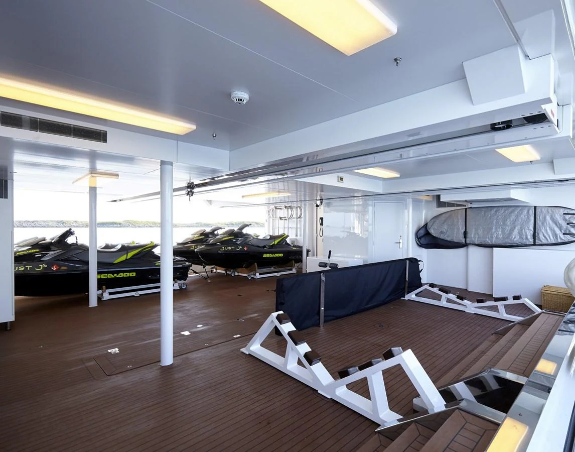 The yacht features a well-organized toy storage area with multiple jet skis and ample space for additional equipment. aboard JUST J'S Yacht for Sale