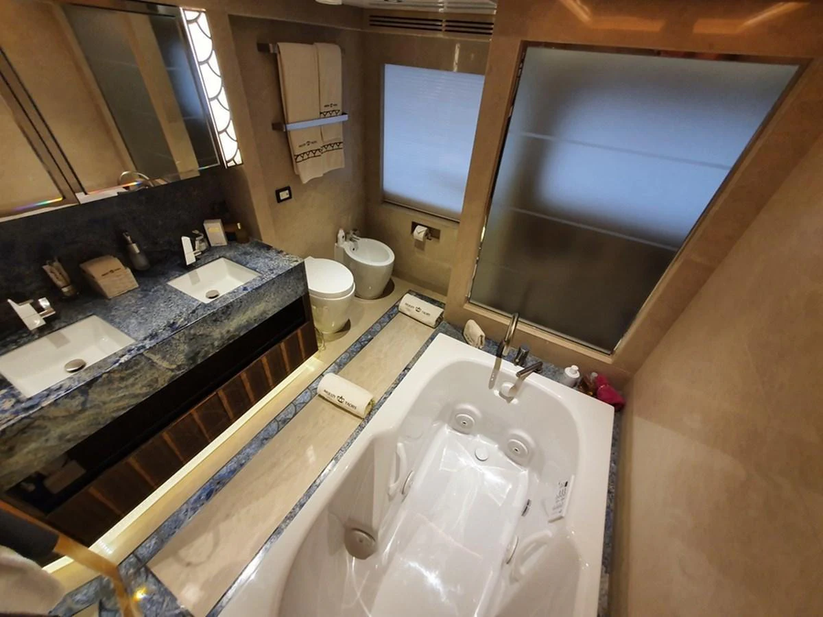 A luxurious yacht bathroom featuring a double sink vanity and a spacious bathtub. aboard AMORE Yacht for Sale