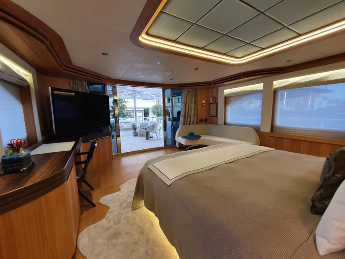 The master stateroom features elegant wood finishes and a spacious layout with a view towards the aft deck. aboard AMORE Yacht for Sale
