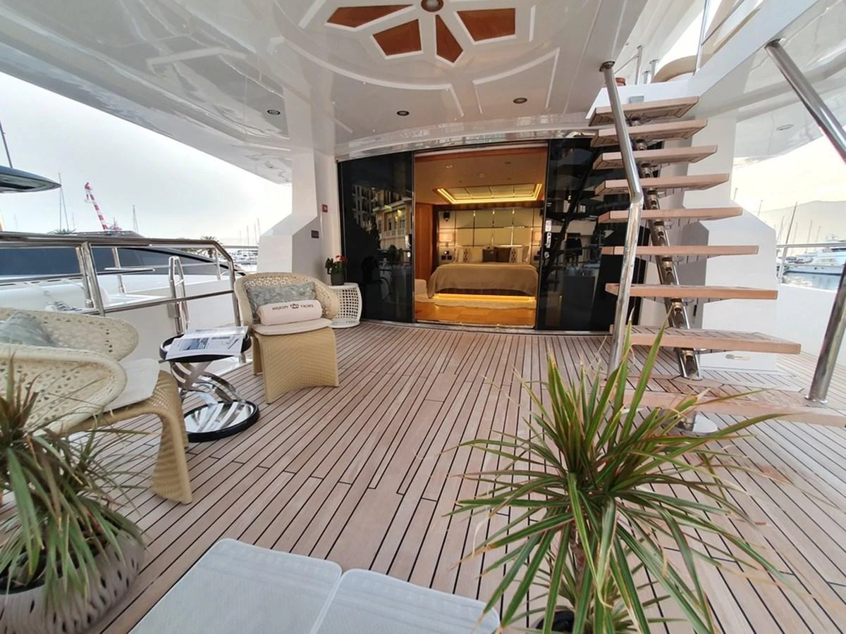 The aft deck features a cozy seating area with direct access to a luxurious stateroom. aboard AMORE Yacht for Sale