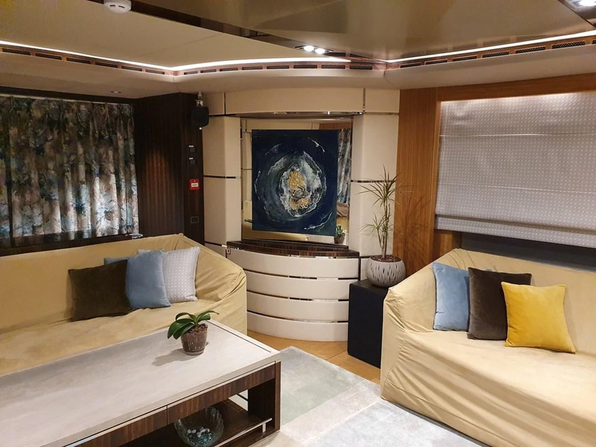 The salon features comfortable seating with elegant decor and a modern art piece as a focal point. aboard AMORE Yacht for Sale
