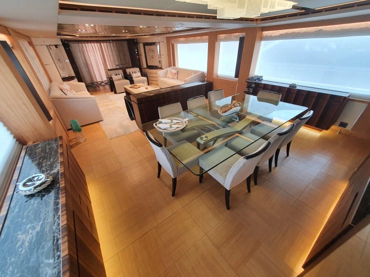 The yacht's salon features a spacious dining area with elegant furnishings and large windows offering ample natural light. aboard AMORE Yacht for Sale