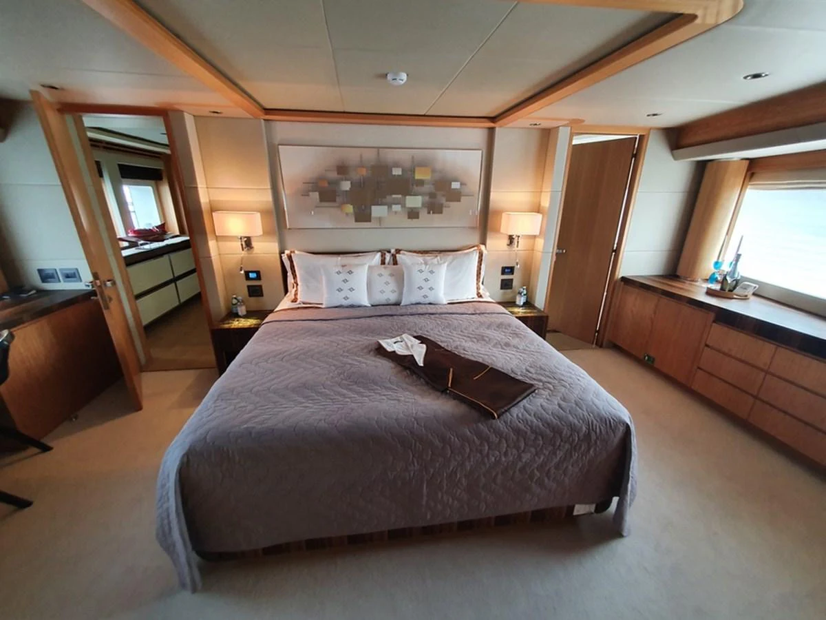 The master stateroom features a luxurious bed with elegant decor and ample natural light. aboard AMORE Yacht for Sale