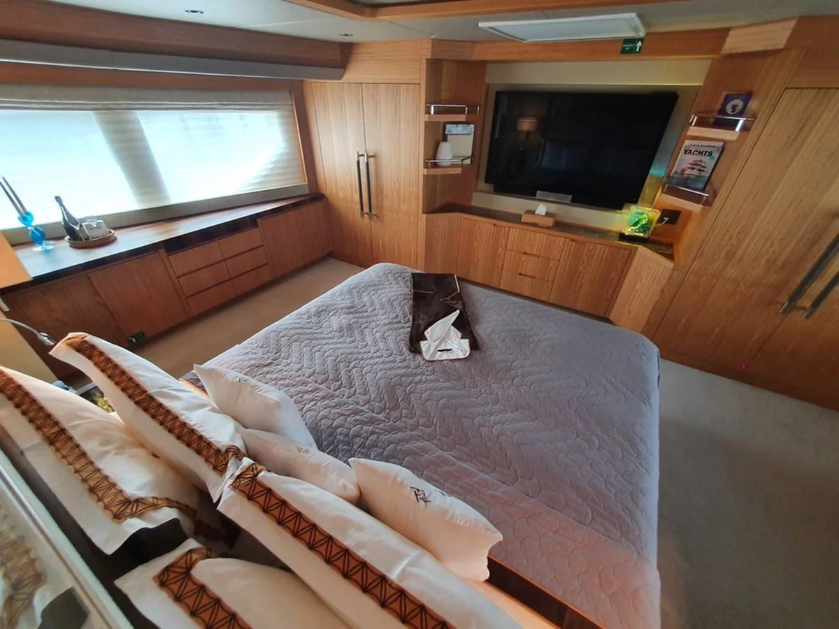 The master stateroom features a spacious bed, ample storage, and a large television for ultimate comfort and relaxation. aboard AMORE Yacht for Sale