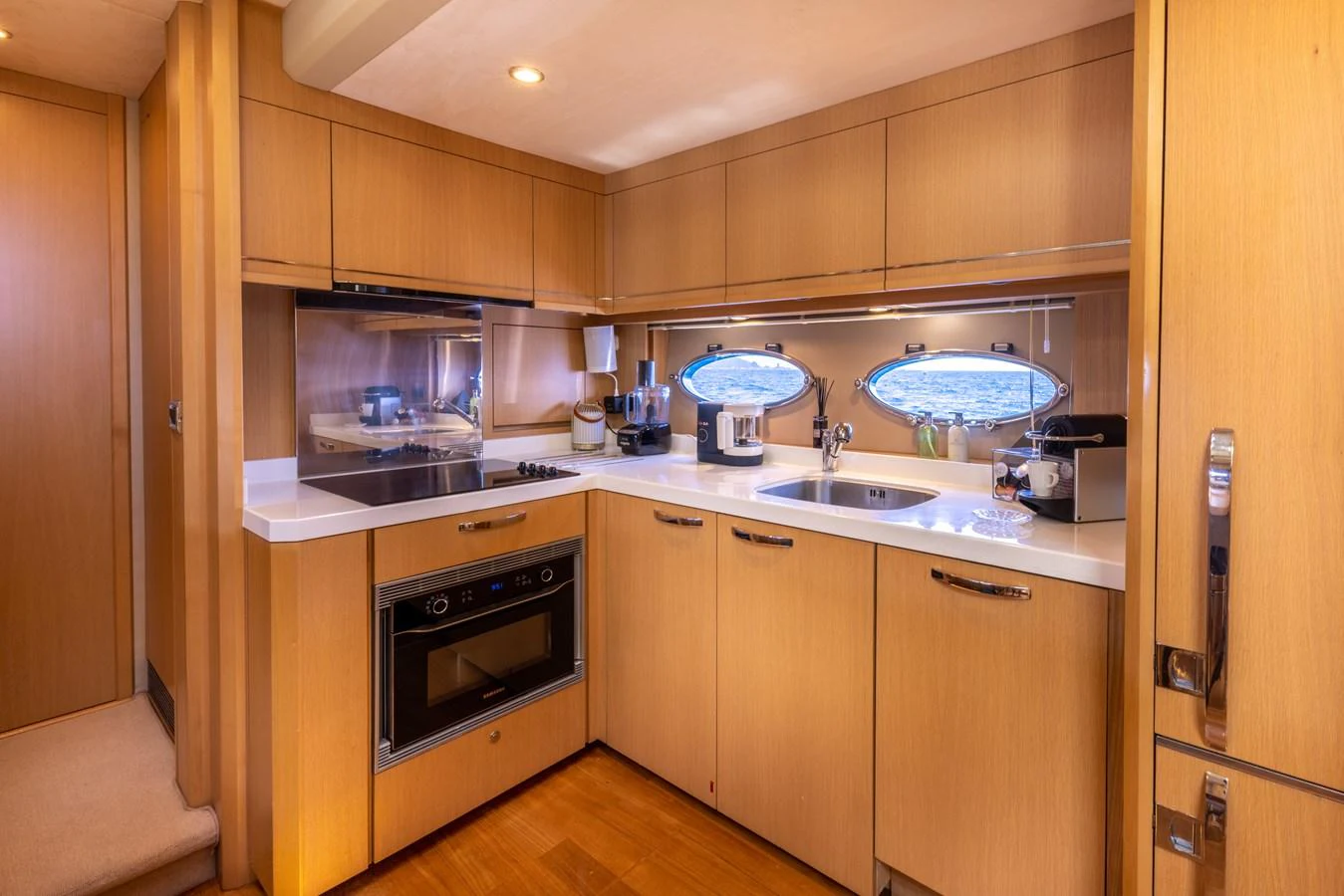 a kitchen with wooden cabinets aboard P'TITE BOUILLE Yacht for Sale
