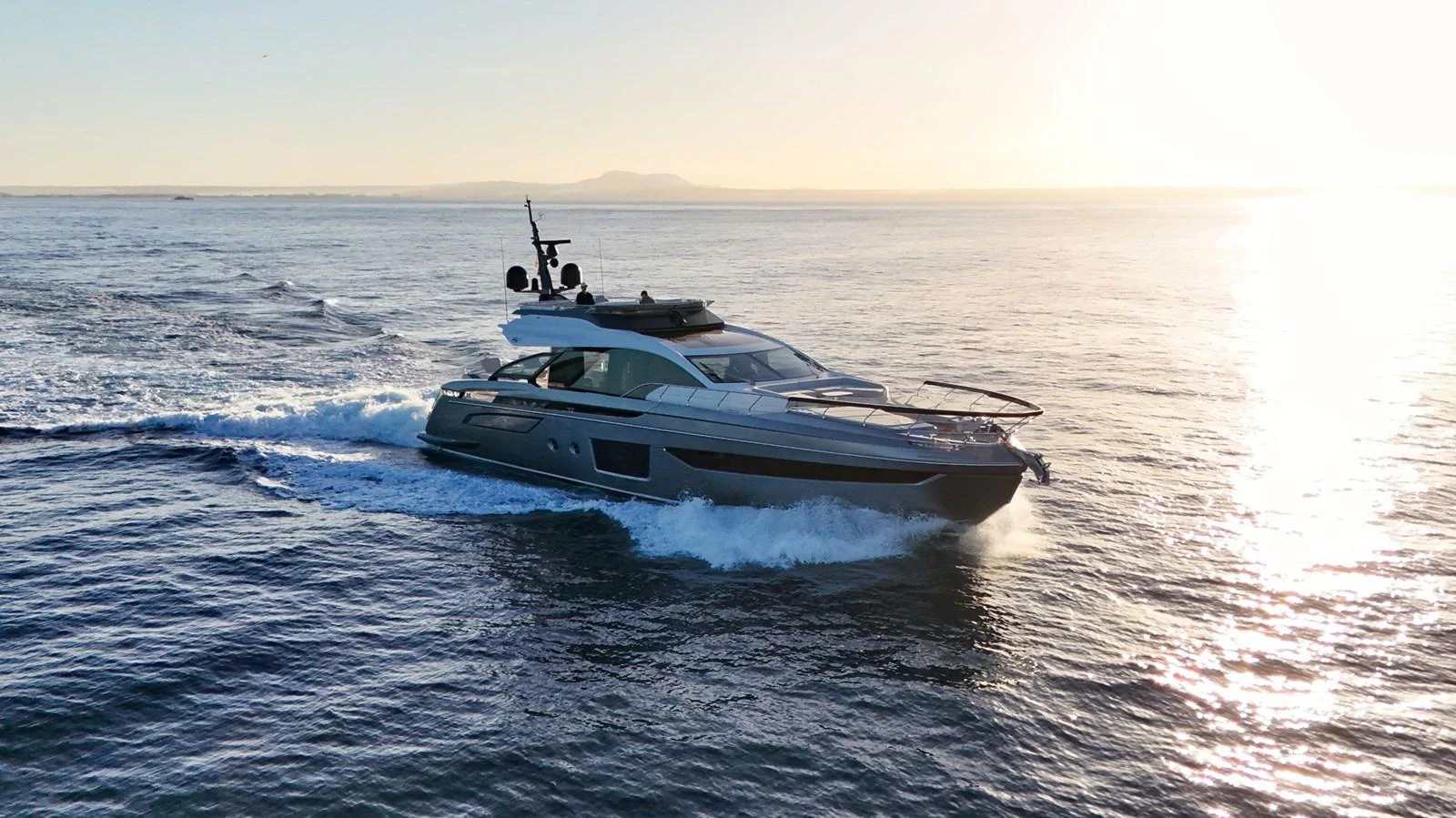 A sleek yacht cruises through calm waters at sunset, showcasing its modern design and powerful performance. aboard APRICITY Yacht for Sale