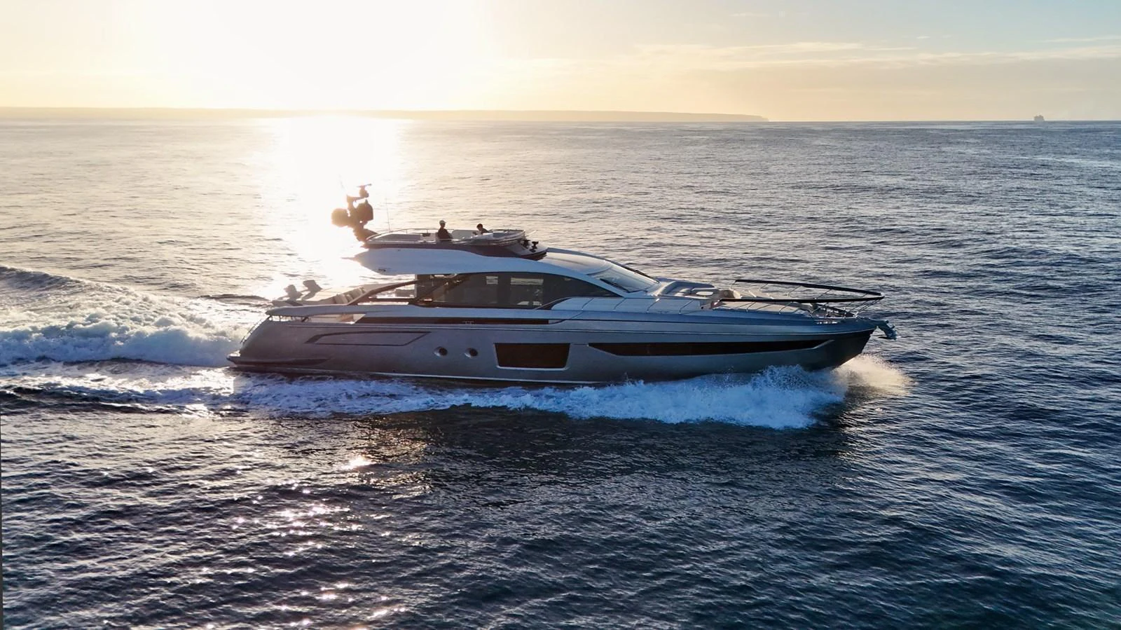 A sleek yacht cruises through the open water at sunset, showcasing its elegant design and powerful performance. aboard APRICITY Yacht for Sale
