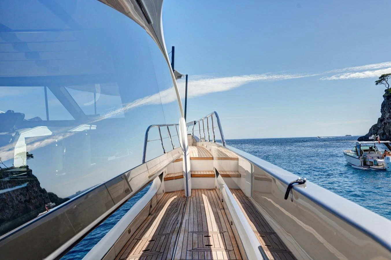 The sleek side deck of the yacht offers a stunning view of the surrounding waters and cliffs. aboard APRICITY Yacht for Sale