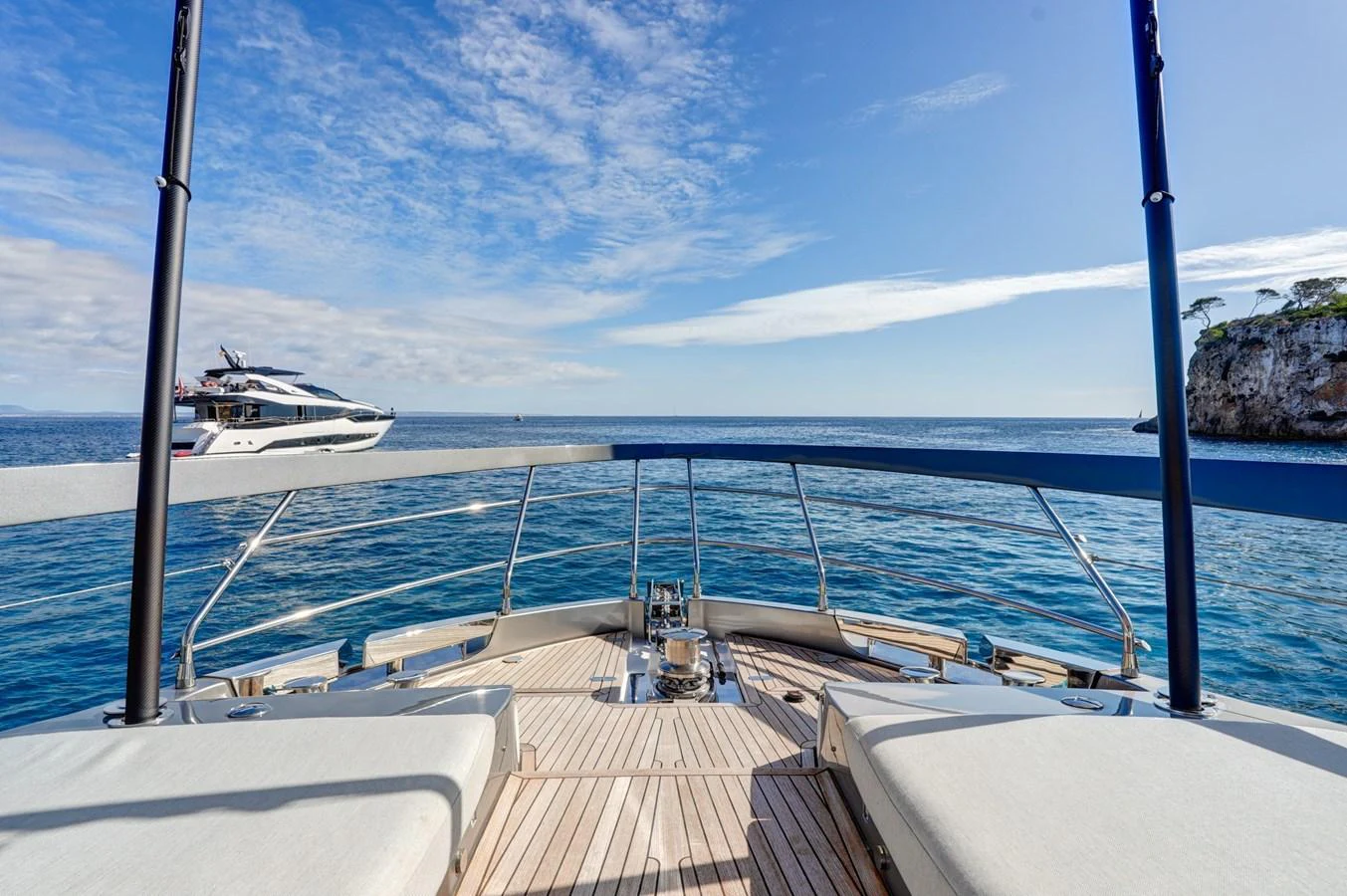 The yacht offers a stunning view from the bow, overlooking the serene blue waters and a distant yacht. aboard APRICITY Yacht for Sale