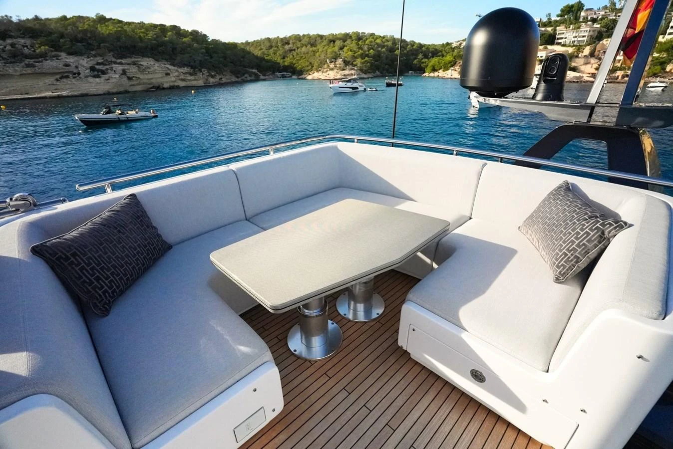 The aft deck features a cozy seating area with a central table, perfect for enjoying the scenic views. aboard APRICITY Yacht for Sale