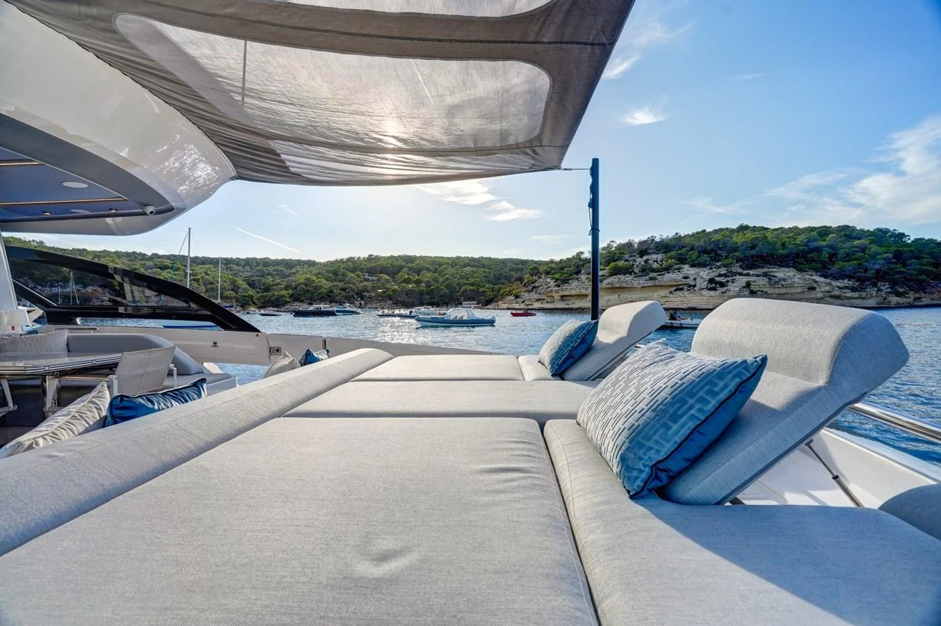 The sundeck offers a luxurious lounging area with plush cushions and a retractable sunshade, perfect for relaxation. aboard APRICITY Yacht for Sale