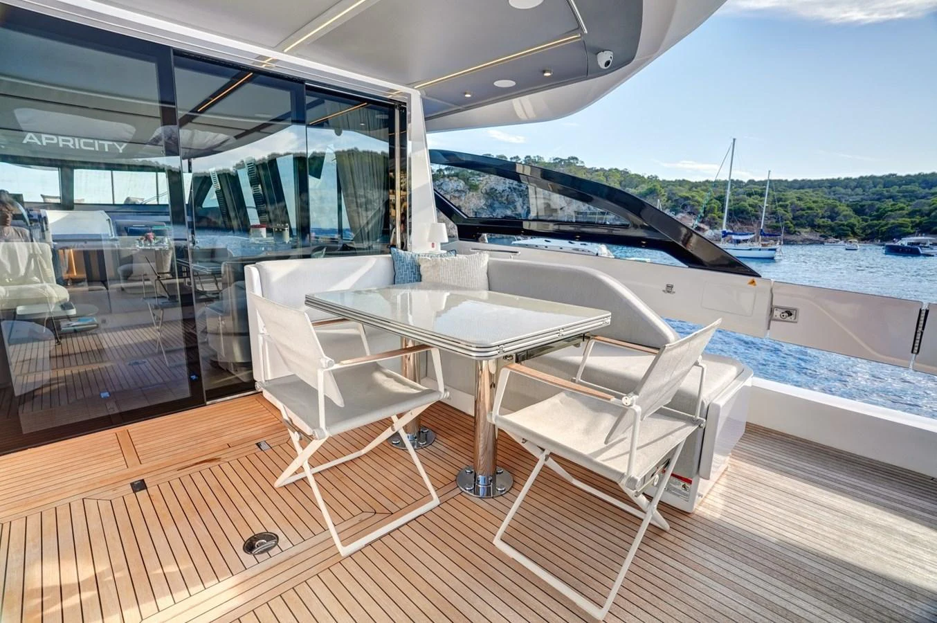 The aft deck features a stylish dining area with a scenic view of the water. aboard APRICITY Yacht for Sale