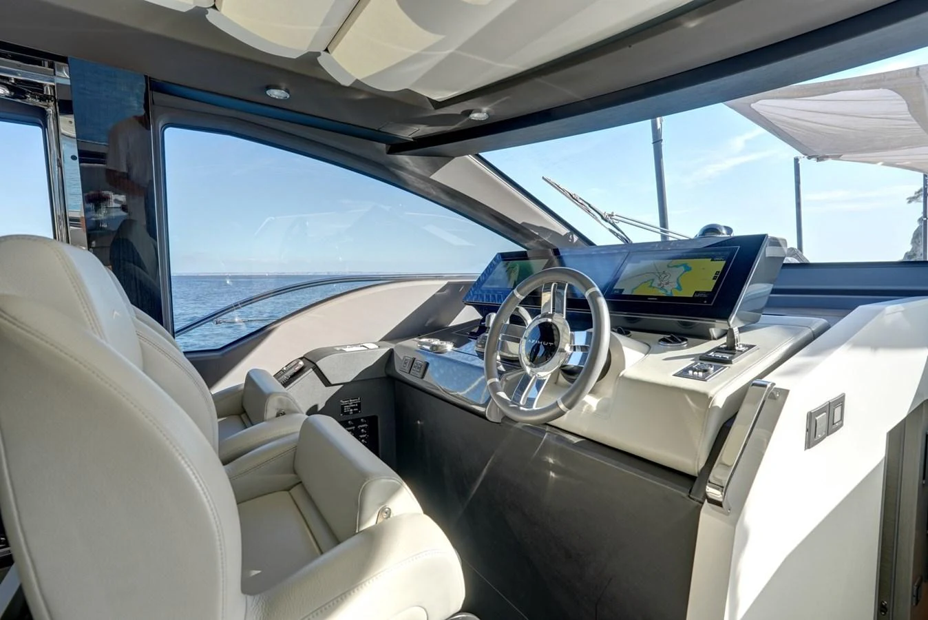 The helm station features modern navigation equipment and luxurious seating with a panoramic view. aboard APRICITY Yacht for Sale